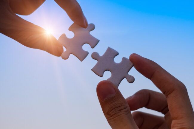 Hands,Connecting,Couple,Puzzle,Piece,Against,Sunrise,Effect,,Businesswoman,Holding